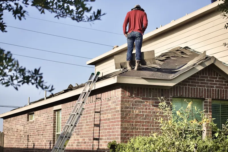 Professional roofer working on a residential roof in Peconic